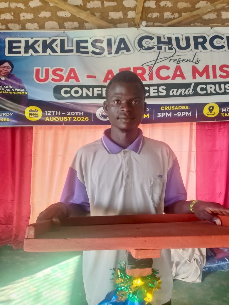 Young man standing under the USA–Africa Mission conference banner