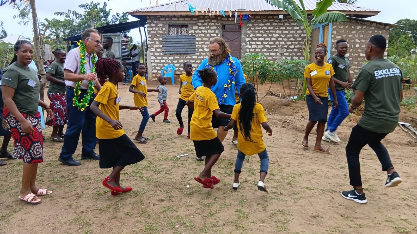 Youth in yellow Ekklesia shirts with visitors at headquarters